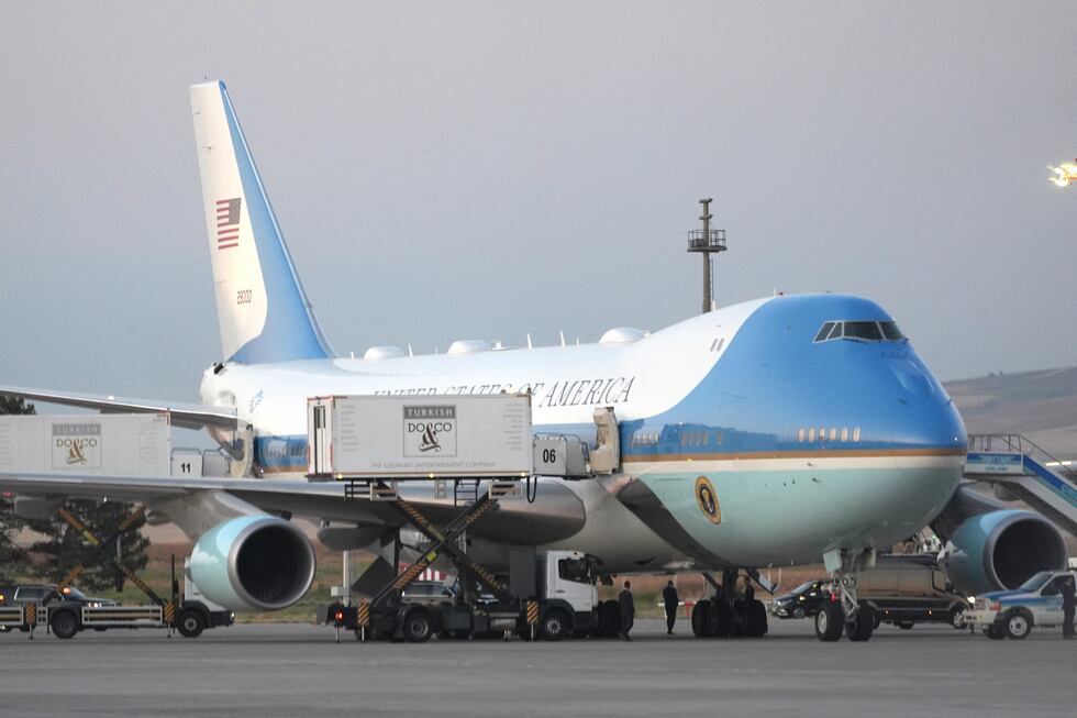 Catering trucks are parked at Air Force One on the tarmac as the motorcade carrying U.S....