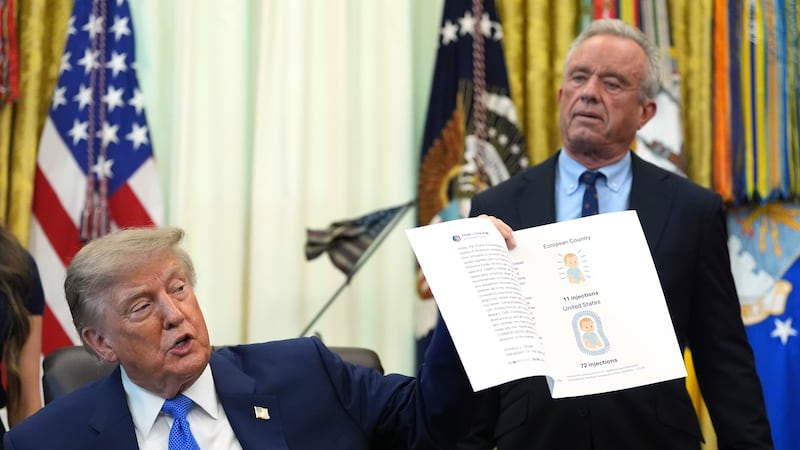 President Donald Trump holds up an image taken from his Truth Social account as Health and...